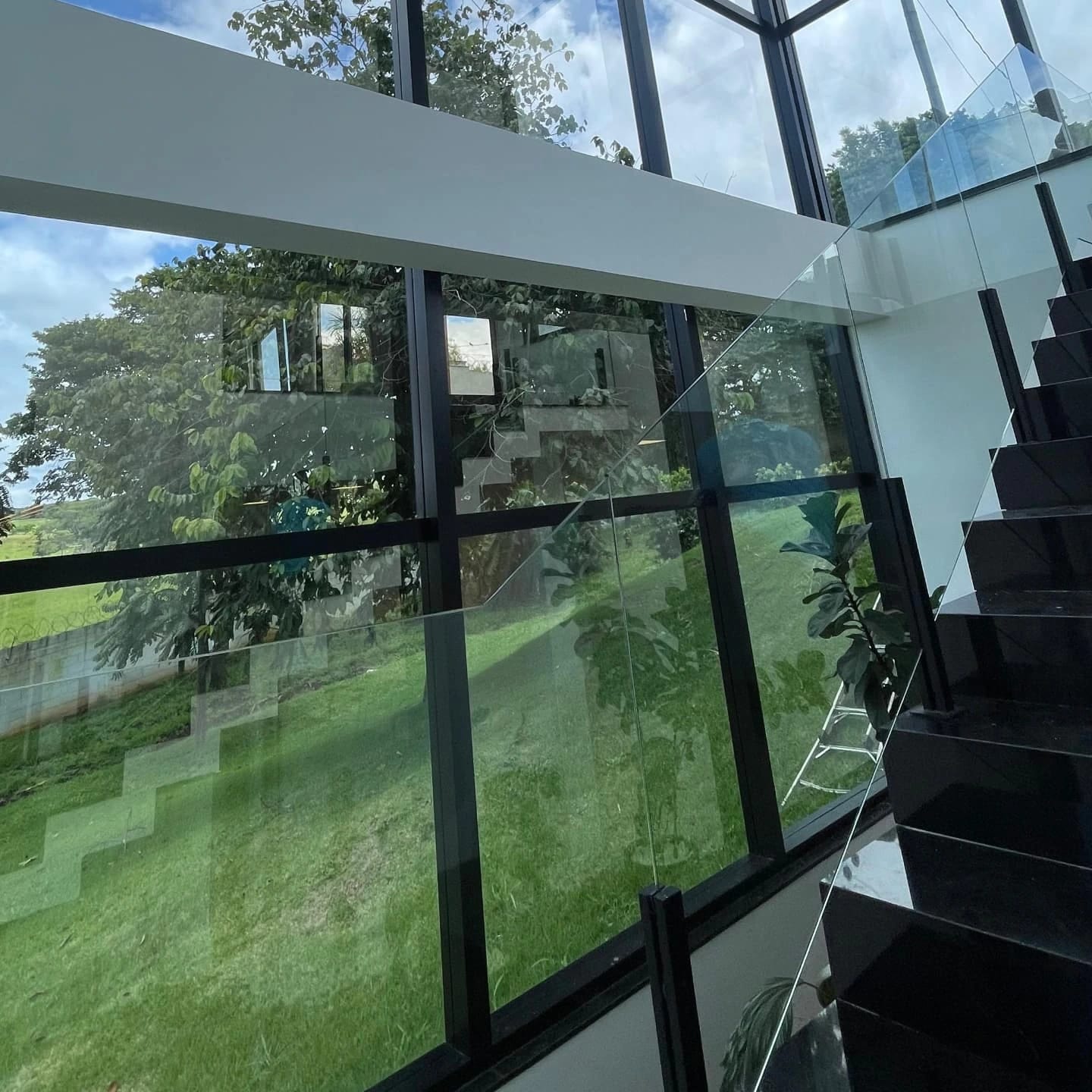 Fachada envidraçada e guarda-corpo de vidro impecáveis